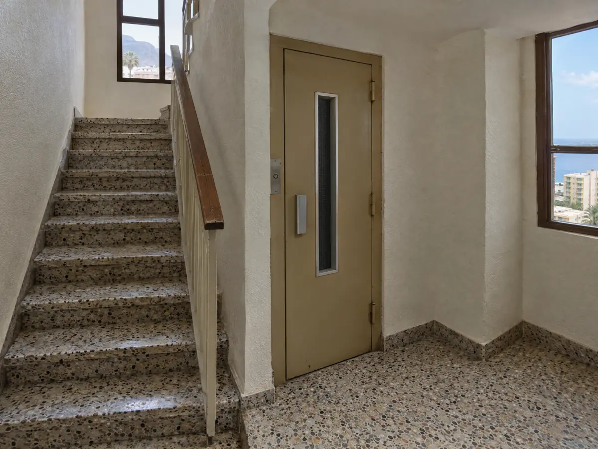 Escalera estrecha y ascensor antiguo de un edificio de los setenta en Santa Cruz de Tenerife