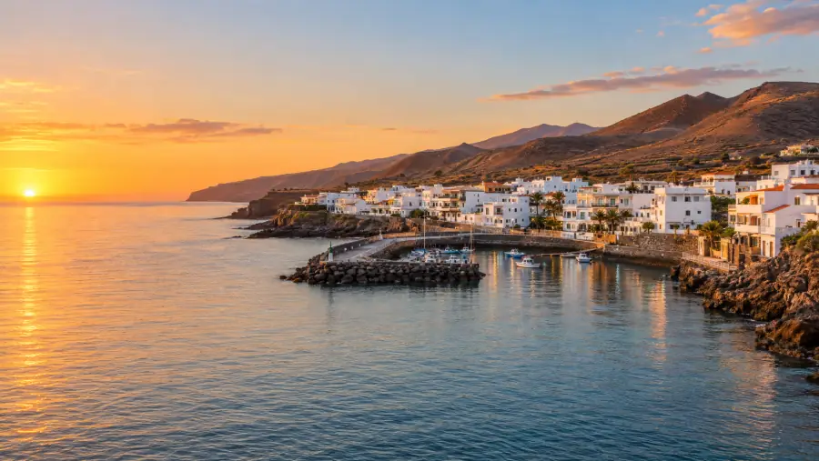 Playa San Juan, en Guía de Isora, con casas blancas junto a la costa al atardecer